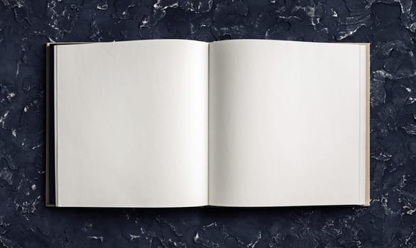 Blank opened booklet on black plaster background. Responsive design template. Top view. Flat lay.