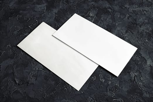 Blank paper envelopes on black plaster background. Template for your design.