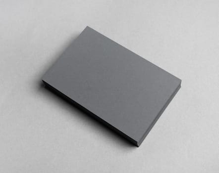 Blank grey business cards stack on paper background.