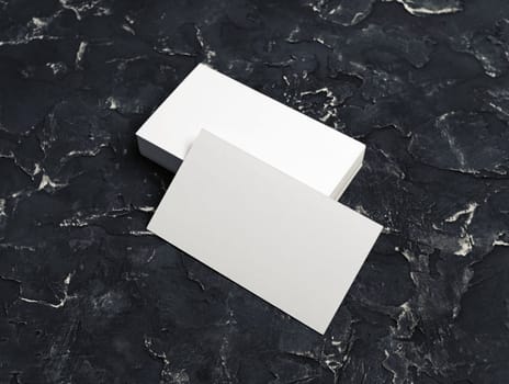 Blank white business cards on black plaster background. Mockup for branding identity.