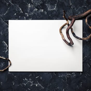 Blank white paper and dry branch on black plaster background. Responsive design mockup. Top view.