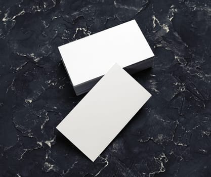 Blank business cards on black plaster background. Mock-up for branding identity.