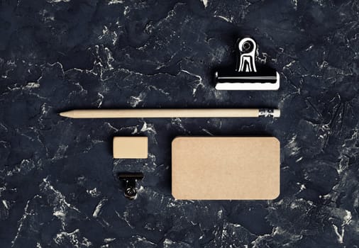 Vintage stationery mockup. Blank kraft business card, pencil, eraser and metal clips. Brand ID set. Top view.