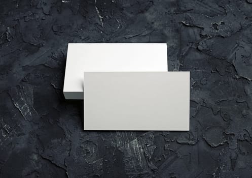 Photo of blank business cards on black plaster background. Mock-up for branding identity for designers.