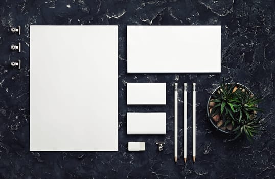 Photo of blank stationery set on black plaster background. Corporate identity mockup. Responsive design template. Top view. Flat lay.