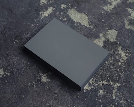 Stack of grey business cards on concrete background. Branding mock up.