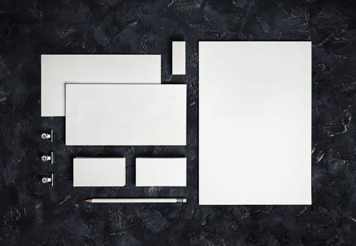 Photo of blank stationery set on black plaster background. Corporate identity template. Responsive design mockup. Top view.