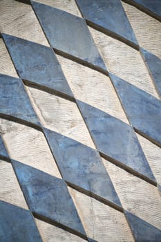 The Bavarian coat of arms in blue and white rhombuses in the Free State of Bavaria on a wall as a background. The surface is rough.