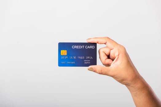 Close up hand of Asian woman she holding bank credit card for pay money online shopping, studio shot isolated on white background