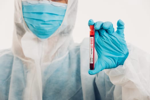 Medical scientist in PPE uniform wear a mask holding test tube Coronavirus test blood sample in a hospital laboratory for analyzing isolated on white, medicine COVID-19 pandemic outbreak concept