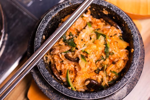 Bibimbap in a black heated stone bowl, Korean traditional dish- bibimbap mixed rice with vegetables Include beef and fried egg, Japanese hot pot food