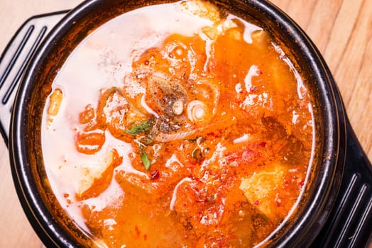 Kimchi soup in hot black iron pot, Korean traditional Kimchi Jjigae soup in bowl in the restaurant, Japanese hot pot food