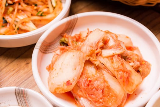 Spicy Kimchi. Korean pickle or Pickled radish vegetables and seasoning on bowl on wood table background, Japanese food