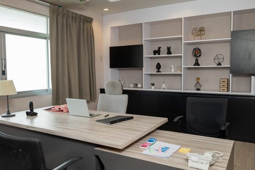 Comfortable office chair near wooden table with laptop computer, Interior of an office desk workspace room, empty no body