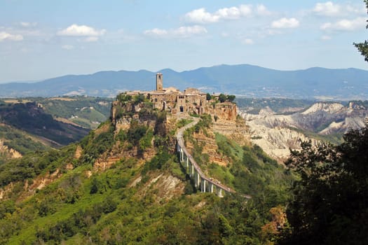 The historical civita village of Bagnoregio standing on a cliff with the long pedestrian bridge in the center of Italy