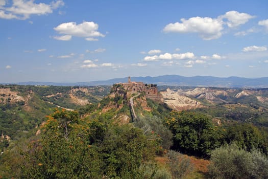 The historical civita village of Bagnoregio standing on a cliff with the long pedestrian bridge in the center of Italy