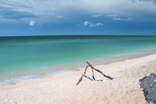 The pyramid pieces of wood on the white sand beach with turquoise Adriatic Sea in Conero in Italy
