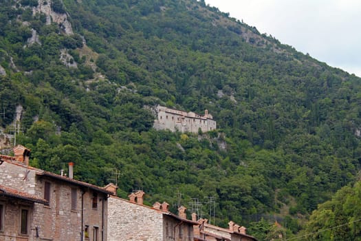 The traditional village on the cliff among the trees in Umbria in Italy