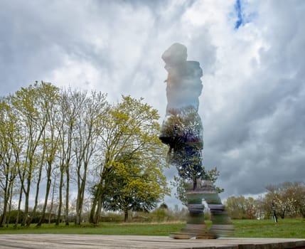 anonymized person, young woman standing on a wooden ground looking down on a group of trees in springtime, cloudy, stormy weather, digitally processed, worms-eye view, proportions changed, hugh person, small trees,