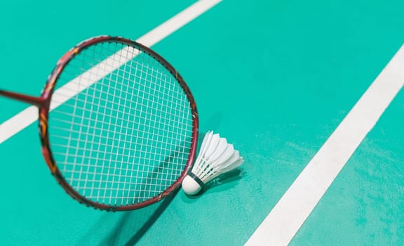 new shuttlecock on green badminton playing court