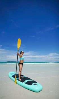 woman on sup board or paddle board at the beach