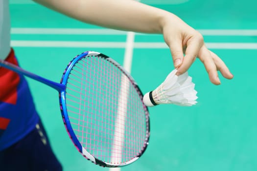 woman holding a badminton racket ready to hit the shuttecock