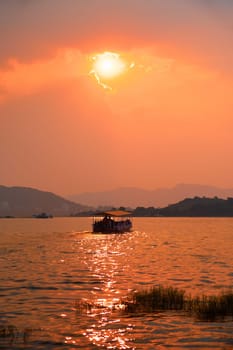 Tourist boat in lake Pichola on sunset. Udaipur, Rajasthan, India