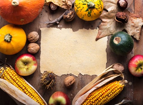 Empty card and autumn crops on wooden background. Thanksgiving concept.