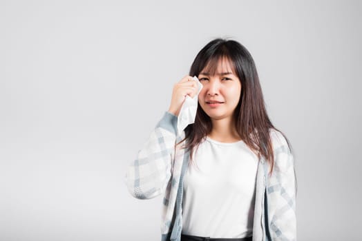 Unhappy woman bad mood her cry wipe mucus with tissue, beautiful young female stress feel sneezing sinus use towel to wipe tear from eyes, studio shot isolated on white background with copy space