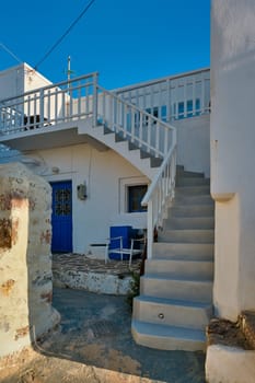 Greek village typical street view with whitewashed houses and stairs. Plaka town, Milos island, Greece
