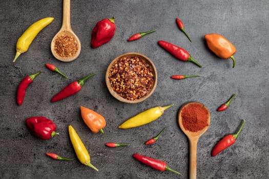 Variety of fresh and dried chili peppers on rustic background