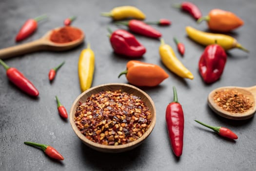 Variety of fresh and dried chili peppers on rustic background