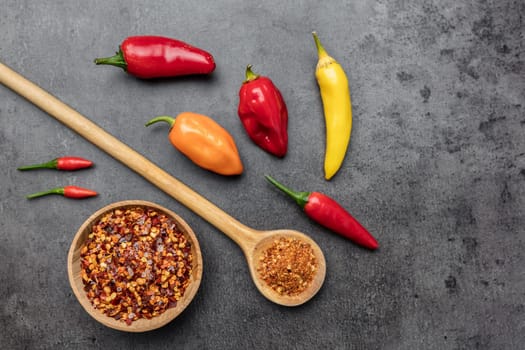 Variety of fresh and dried chili peppers on rustic background
