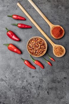 Variety of fresh and dried chili peppers on rustic background