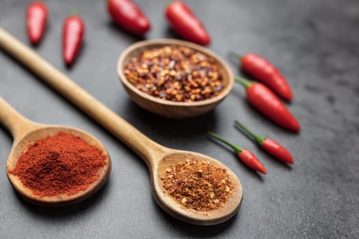 Variety of fresh and dried chili peppers on rustic background