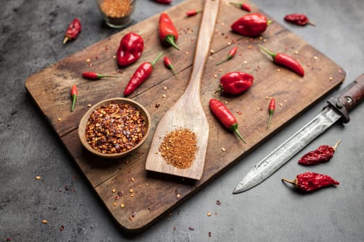 Variety of fresh and dried chili peppers on rustic background