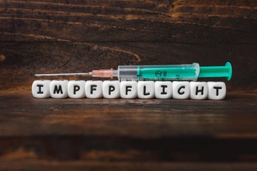 Corona virus Covid-19 vaccine text in German on wooden background