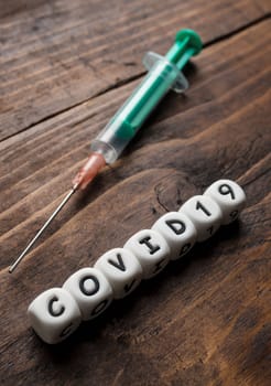 Corona virus Covid-19 vaccine text on wooden background