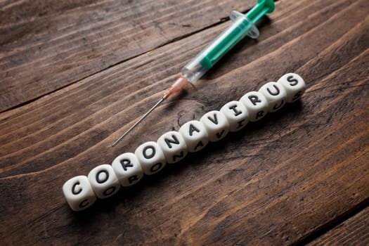 Corona virus Covid-19 vaccine text on wooden background