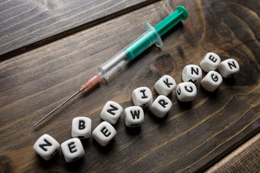 Corona virus Covid-19 vaccine text in German on wooden background
