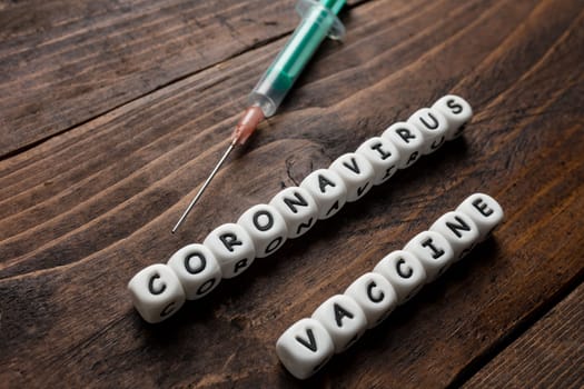 Corona virus Covid-19 vaccine text on wooden background