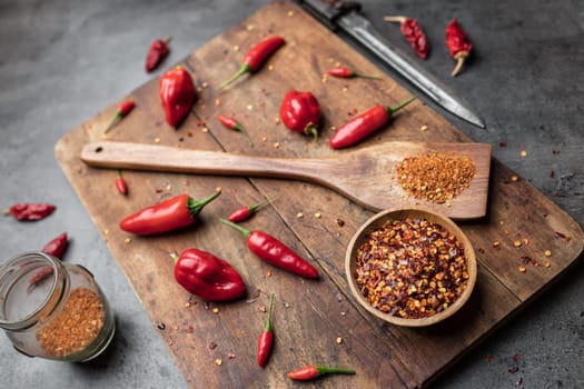 Variety of fresh and dried chili peppers on rustic background