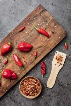 Variety of fresh and dried chili peppers on rustic background