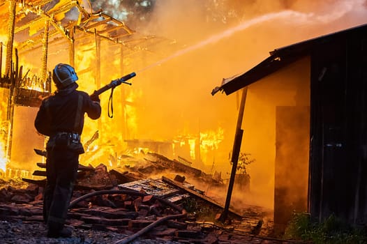 Firefighters extinguish a fire in a farm building. High quality photo