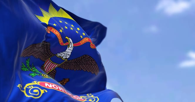 The US state flag of North Dakota waving in the wind. North Dakota is a U.S. state in the Upper Midwest region of the United States. Democracy and independence.