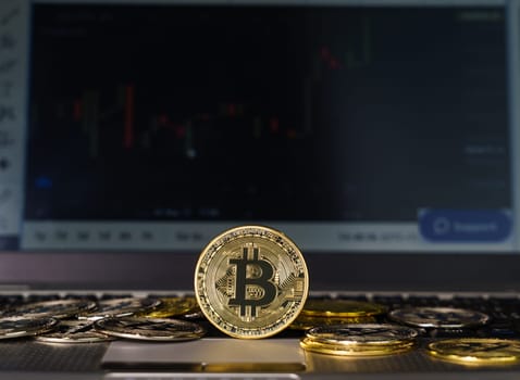 Bitcoins coin on keyboard computer. Close up of  bitcoin crypto currency coins with trading exchange market price chart