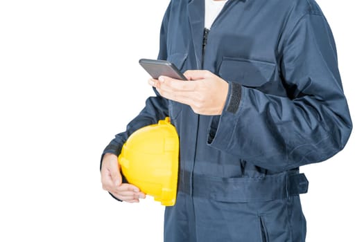Cloes up Worker standing in blue coverall holding yellow hardhat and use smartphone isolated on white background