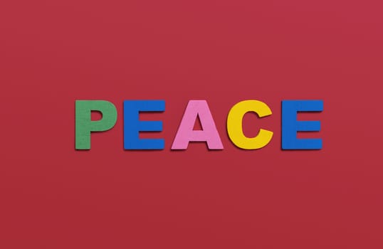 Peace, word written in colorful wooden alphabet letters on red background. The concept of a terrible war destroying country. Top view. Copy space