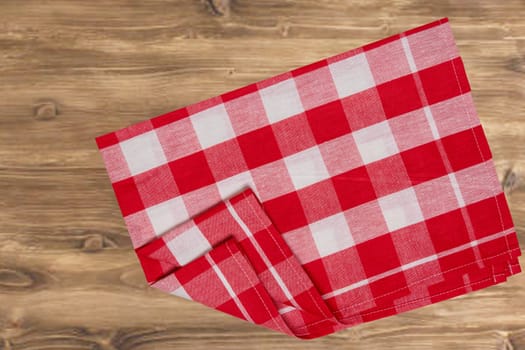 Empty table product. Top view of a rustic wooden table with a red and white checkered tablecloth or napkin. Template for your food and product display montage. Space for food recipe.