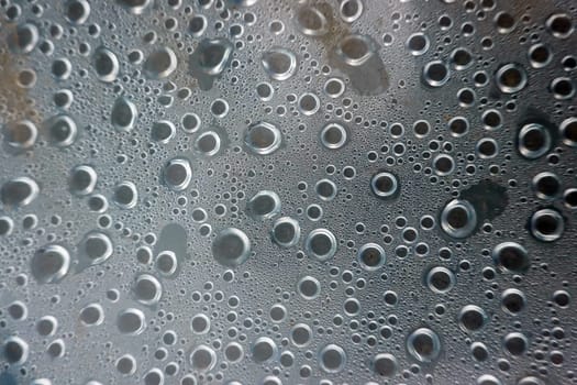 Kondenswasser-Tropfen bilden ein abstraktes Muster unter einer Plastikfolie